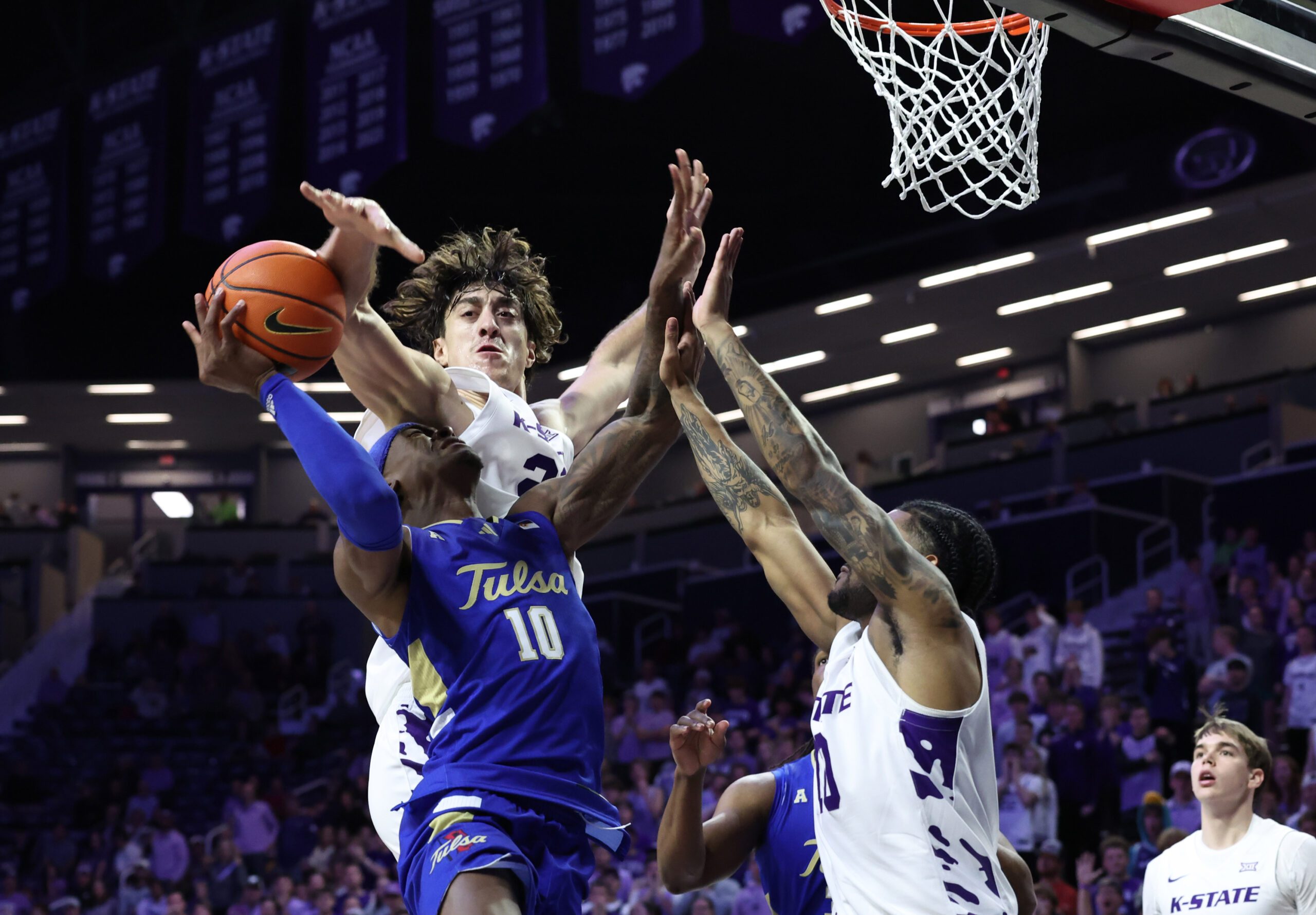 Nov 17, 2025; Manhattan, Kansas, USA; Tulsa Golden Hurricane guard Tylen Riley (10) is guarded by Kansas State Wildcats center Dorin Buca (22) and guard David Castillo (10) during the second half at Bramlage Coliseum. Mandatory Credit: Scott Sewell-Imagn Images