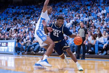 Nov 18, 2025; Chapel Hill, North Carolina, USA; Navy Midshipmen guard Jordan Pennick (21) drives on North Carolina Tar Heels forward Jarin Stevenson (15) during the first half at Dean E. Smith Center. Mandatory Credit: Scott Kinser-Imagn Images