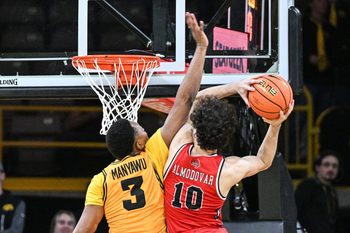 Nov 18, 2025; Iowa City, Iowa, USA; Iowa Hawkeyes forward Cam Manyawu (3) defends Southeast Missouri State Redhawks guard Luke Almodovar (10) as he goes to the basket during the second half at Carver-Hawkeye Arena. Mandatory Credit: Jeffrey Becker-Imagn Images