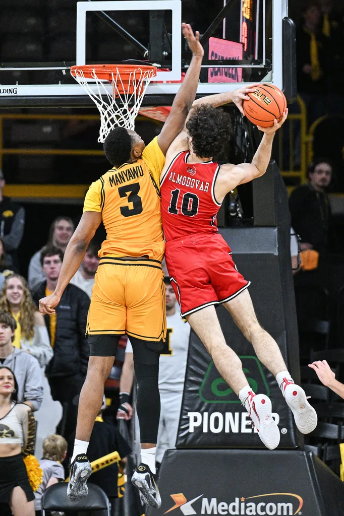 Nov 18, 2025; Iowa City, Iowa, USA; Iowa Hawkeyes forward Cam Manyawu (3) defends Southeast Missouri State Redhawks guard Luke Almodovar (10) as he goes to the basket during the second half at Carver-Hawkeye Arena. Mandatory Credit: Jeffrey Becker-Imagn Images