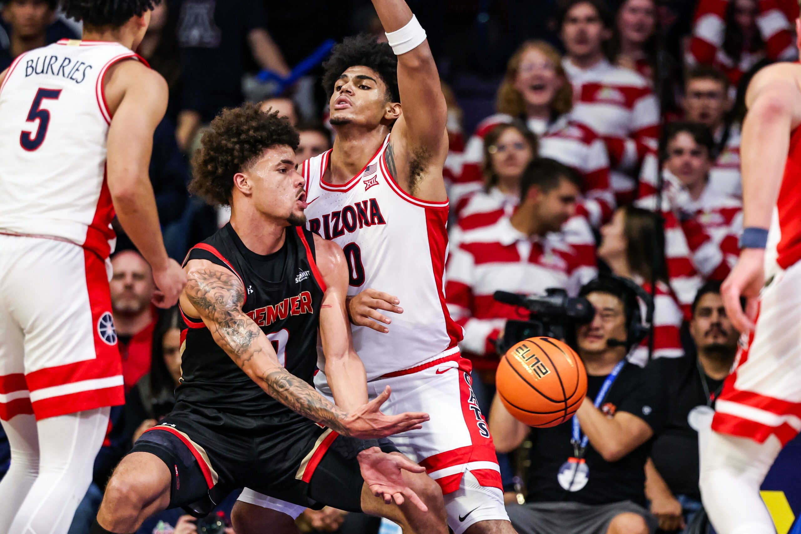 Nov 24, 2025; Tucson, Arizona, USA; Denver Pioneers forward Jeremiah Burke (0) passes the ball during the second half of the game against the Arizona Wildcats at McKale Memorial Center. Mandatory Credit: Aryanna Frank-Imagn Images