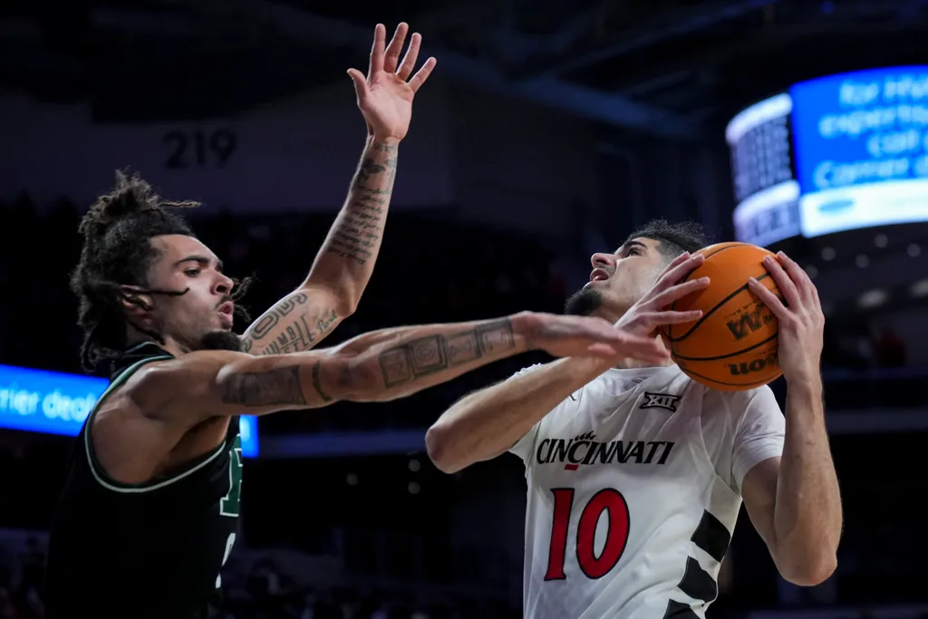 Nov 26, 2025; Cincinnati, Ohio, USA; Cincinnati Bearcats guard Shon Abaev (10) drives to the basket against Eastern Michigan Eagles guard Addison Patterson (9) in the second half at Fifth Third Arena. Mandatory Credit: Aaron Doster-Imagn Images