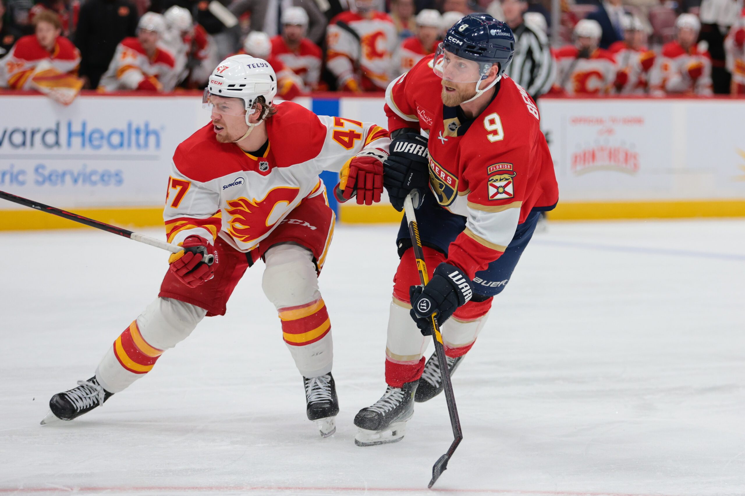 Nov 28, 2025; Sunrise, Florida, USA; Florida Panthers center Sam Bennett (9) shoots the puck against Calgary Flames center Connor Zary (47) during the third period at Amerant Bank Arena. Mandatory Credit: Sam Navarro-Imagn Images
