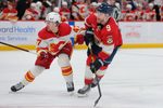 Nov 28, 2025; Sunrise, Florida, USA; Florida Panthers center Sam Bennett (9) shoots the puck against Calgary Flames center Connor Zary (47) during the third period at Amerant Bank Arena. Mandatory Credit: Sam Navarro-Imagn Images
