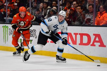 Dec 3, 2025; Anaheim, California, USA; Utah Mammoth center Logan Cooley (92) moves the puck ahead of Anaheim Ducks defenseman Jackson Lacombe (2) during the second period at Honda Center. Mandatory Credit: Gary A. Vasquez-Imagn Images