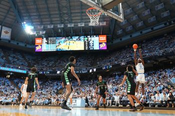 Dec 13, 2025; Chapel Hill, North Carolina, USA; North Carolina Tar Heels forward Caleb Wilson (8) shoots as USC Upstate Spartans guard Mason Bendinger (9) defends in the second half at Dean E. Smith Center. Mandatory Credit: Bob Donnan-Imagn Images