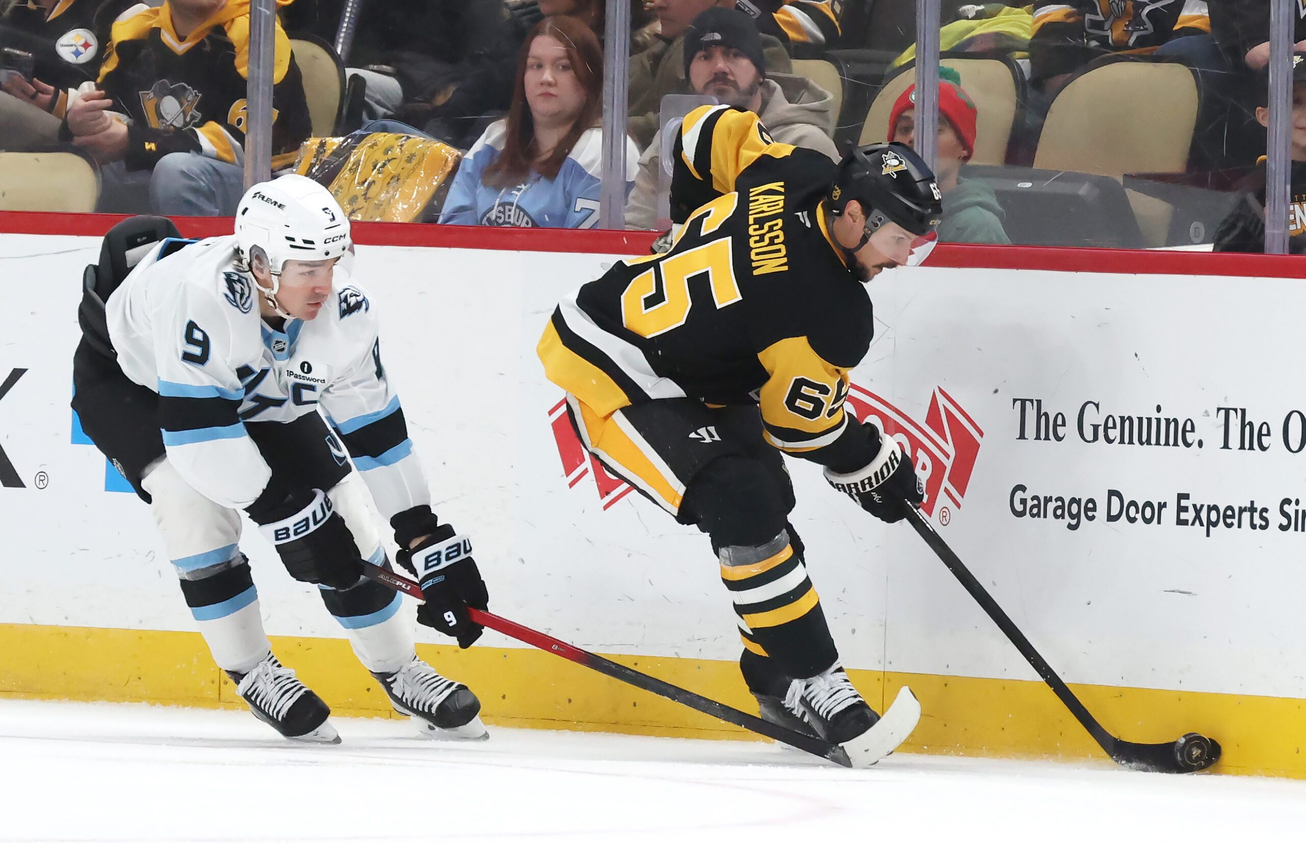 Dec 14, 2025; Pittsburgh, Pennsylvania, USA;  Pittsburgh Penguins defenseman Erik Karlsson (65) moves the puck against Utah Mammoth right wing Clayton Keller (9) during the third period at PPG Paints Arena. Mandatory Credit: Charles LeClaire-Imagn Images
