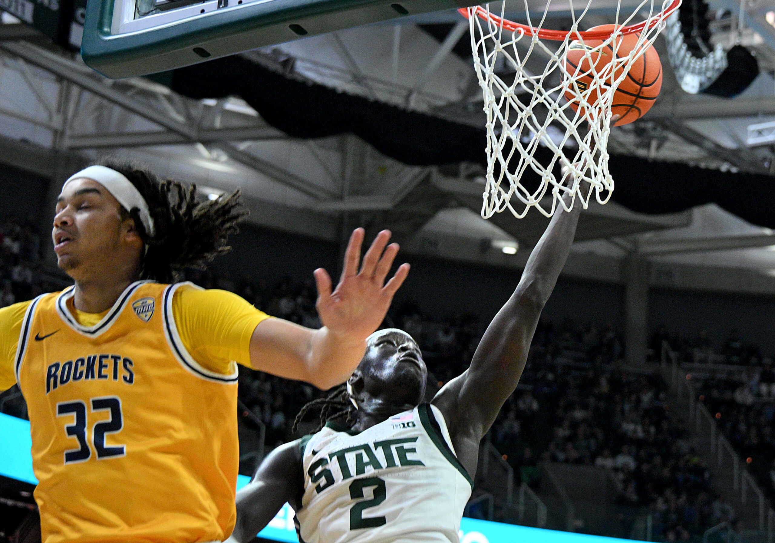 Dec 16, 2025; East Lansing, Michigan, USA; Michigan State Spartans guard Kur Teng (2) slashes in for a basket behind Toledo Rockets forward Jaylan Ouwinga (32) during the second half at Jack Breslin Student Events Center. Mandatory Credit: Dale Young-Imagn Images