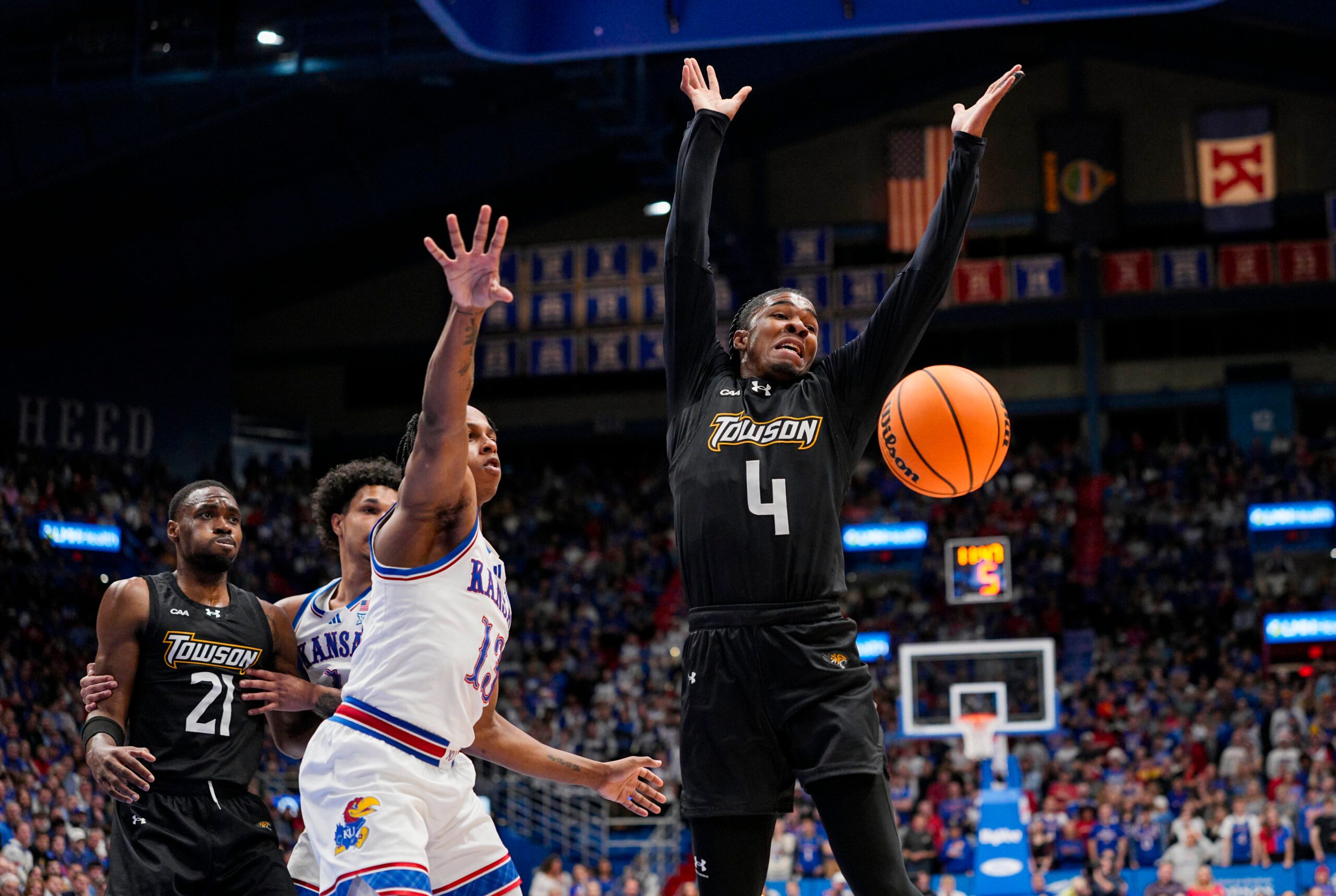 Dec 16, 2025; Lawrence, Kansas, USA; Kansas Jayhawks guard Elmarko Jackson (13) knocks the ball away from Towson Tigers guard Dylan Williamson (4) during the first half at Allen Fieldhouse. Mandatory Credit: Jay Biggerstaff-Imagn Images