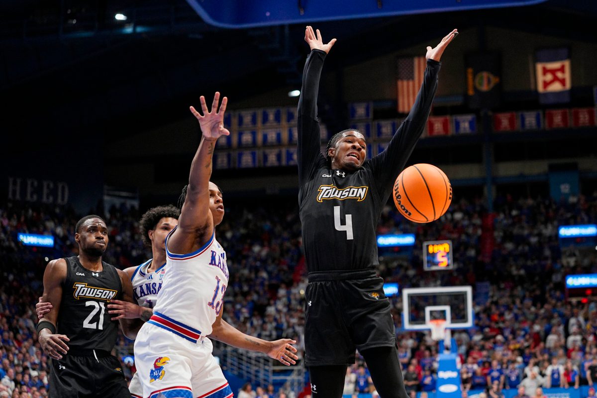 Dec 16, 2025; Lawrence, Kansas, USA; Kansas Jayhawks guard Elmarko Jackson (13) knocks the ball away from Towson Tigers guard Dylan Williamson (4) during the first half at Allen Fieldhouse. Mandatory Credit: Jay Biggerstaff-Imagn Images