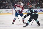 Dec 16, 2025; Seattle, Washington, USA; Colorado Avalanche center Brock Nelson (11) plays the puck while defended by Seattle Kraken right wing Eeli Tolvanen (20) during the third period at Climate Pledge Arena. Mandatory Credit: Steven Bisig-Imagn Images