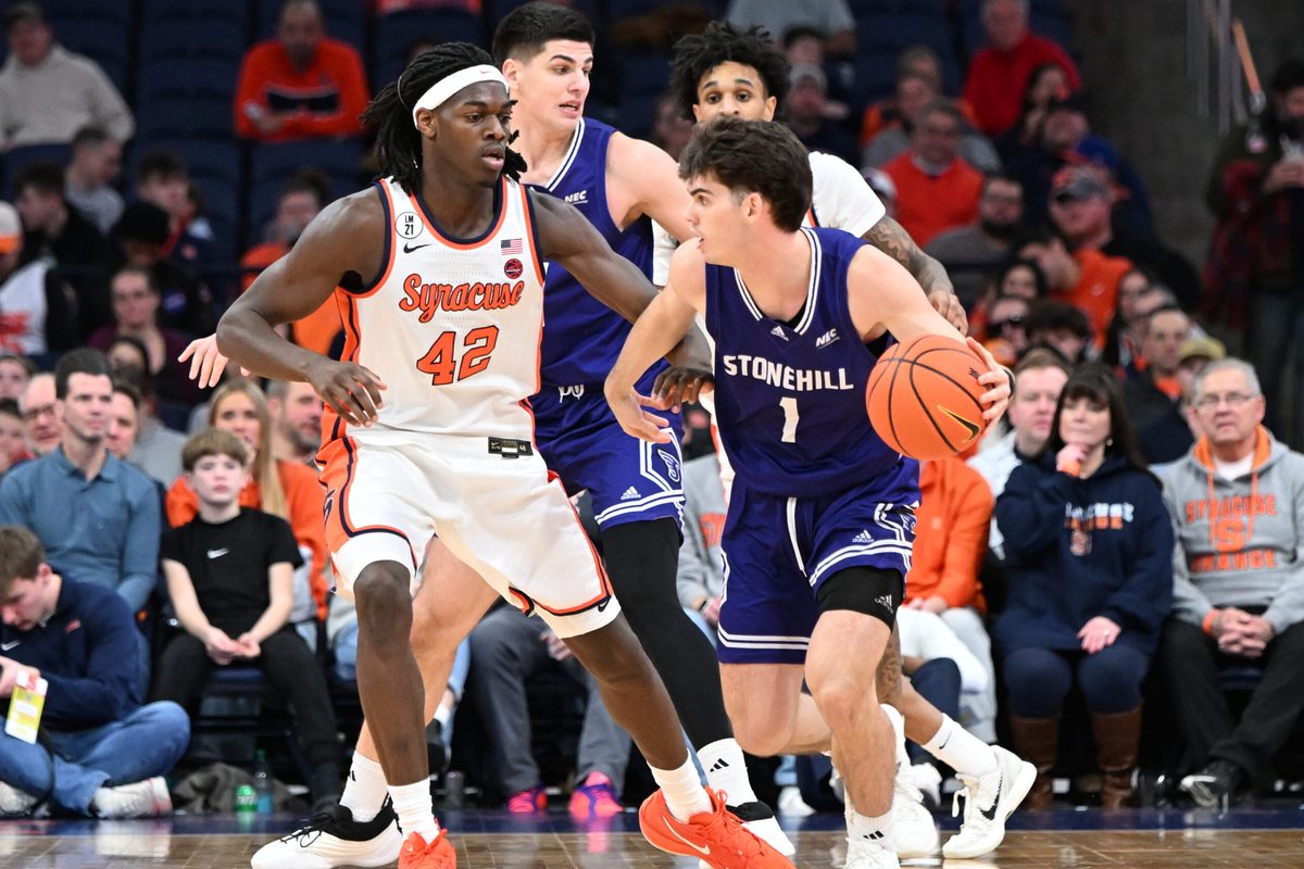 Dec 22, 2025; Syracuse, New York, USA; Stonehill Skyhawks guard Rex Sunderland (1) is defended by Syracuse Orange forward William Kyle III (42) in the second half at the JMA Wireless Dome. Mandatory Credit: Mark Konezny-Imagn Images