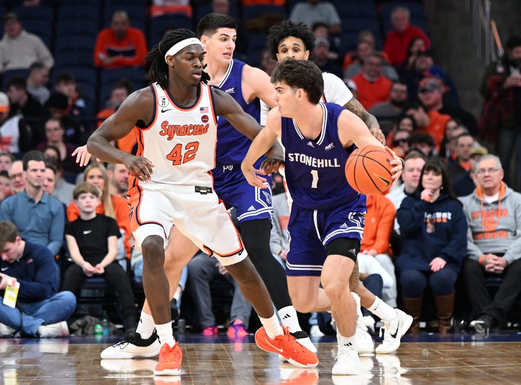 Dec 22, 2025; Syracuse, New York, USA; Stonehill Skyhawks guard Rex Sunderland (1) is defended by Syracuse Orange forward William Kyle III (42) in the second half at the JMA Wireless Dome. Mandatory Credit: Mark Konezny-Imagn Images