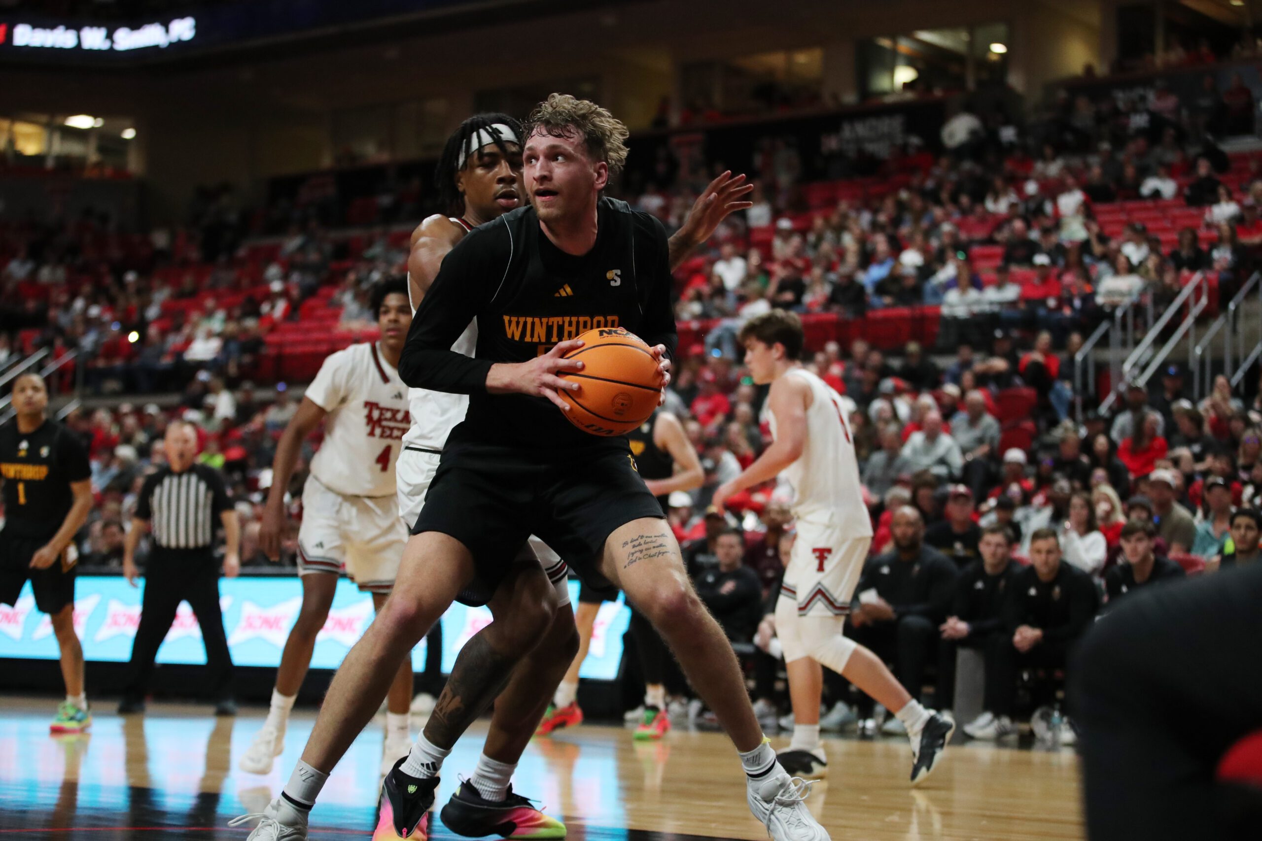 Dec 28, 2025; Lubbock, Texas, USA;  Winthrop Eagles center Logan Duncomb (51) holds the ball against Texas Tech Red Raiders forward JT Toppin (15) in the second half at United Supermarkets Arena. Mandatory Credit: Michael C. Johnson-Imagn Images