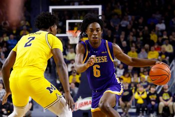 Dec 29, 2025; Ann Arbor, Michigan, USA;  McNeese Cowboys guard Larry Johnson (6) dribbles defended by Michigan Wolverines guard L.J. Cason (2) in the second half at Crisler Center. Mandatory Credit: Rick Osentoski-Imagn Images