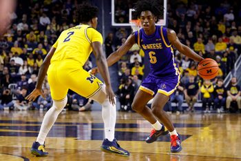 Dec 29, 2025; Ann Arbor, Michigan, USA;  McNeese Cowboys guard Larry Johnson (6) dribbles defended by Michigan Wolverines guard L.J. Cason (2) in the second half at Crisler Center. Mandatory Credit: Rick Osentoski-Imagn Images