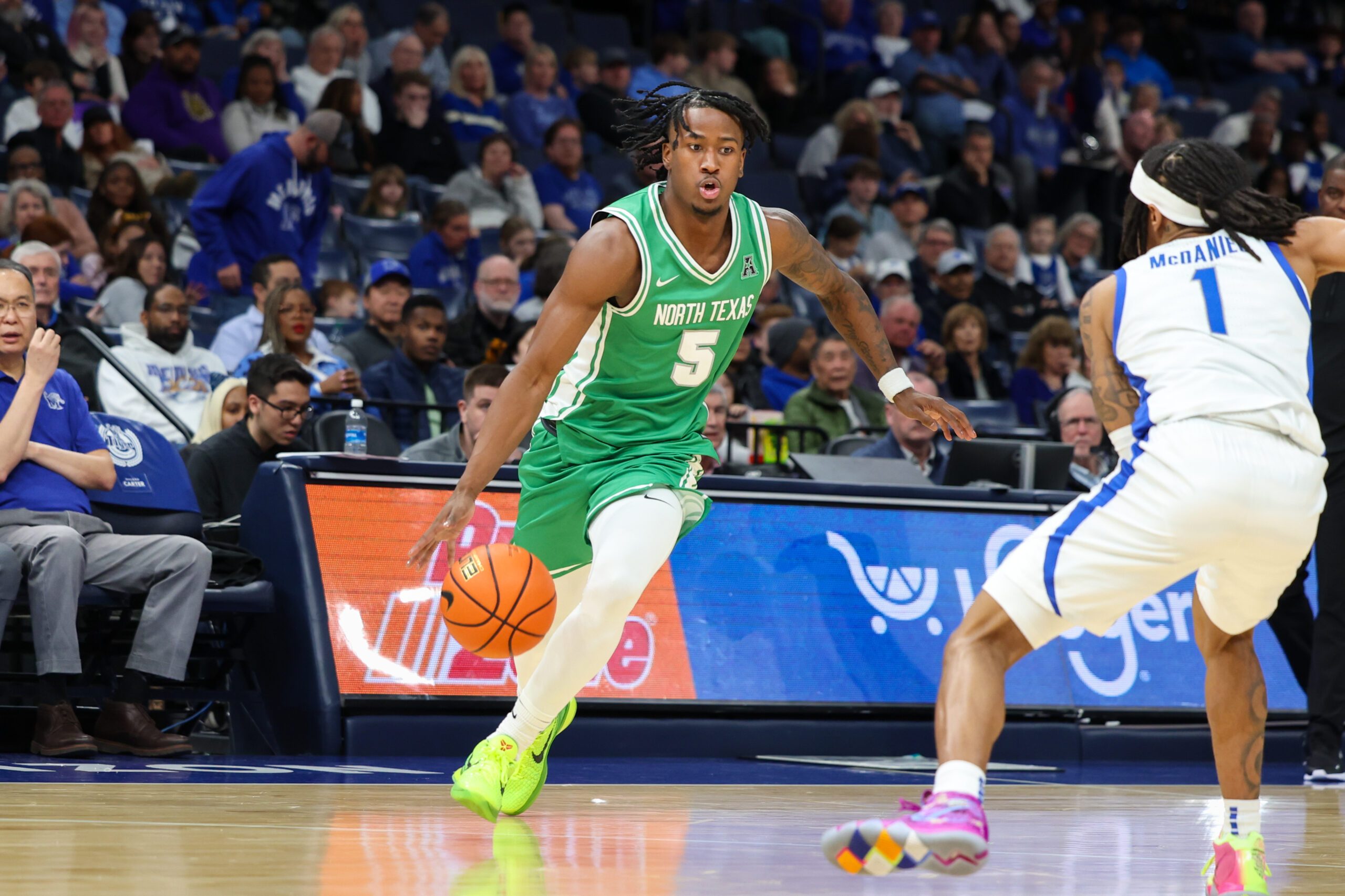 Dec 31, 2025; Memphis, Tennessee, USA; North Texas Mean Green guard David Terrell Jr. (5) drives to the basket against Memphis Tigers guard Dug McDaniel (1) during the second half at FedExForum. Mandatory Credit: Wesley Hale-Imagn Images