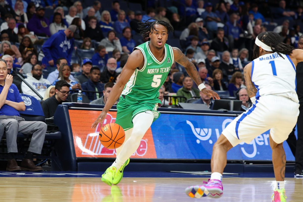 Dec 31, 2025; Memphis, Tennessee, USA; North Texas Mean Green guard David Terrell Jr. (5) drives to the basket against Memphis Tigers guard Dug McDaniel (1) during the second half at FedExForum. Mandatory Credit: Wesley Hale-Imagn Images