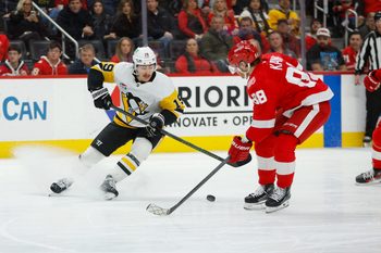 Jan 3, 2026; Detroit, Michigan, USA; Pittsburgh Penguins center Connor Dewar (19) handles the puck against Detroit Red Wings right wing Patrick Kane (88) during the first period at Little Caesars Arena. Mandatory Credit: Brian Bradshaw Sevald-Imagn Images