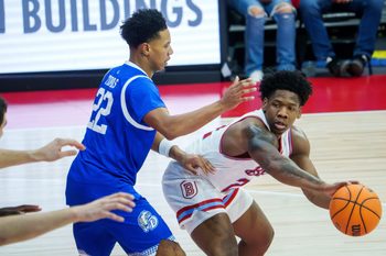 Bradley’s Jaquan Johnson, far right, passes the ball around Drake’s Jaehshon in the first half of their college basketball game Wednesday, Jan. 7, 2026 at Carver Arena in Peoria. The Braves defeated the Bulldogs 93-66.