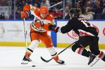 Jan 10, 2026; Buffalo, New York, USA;  Anaheim Ducks center Mikael Granlund (64) looks to control the puck as Buffalo Sabres left wing Jason Zucker (17) defends during the third period at KeyBank Center. Mandatory Credit: Timothy T. Ludwig-Imagn Images