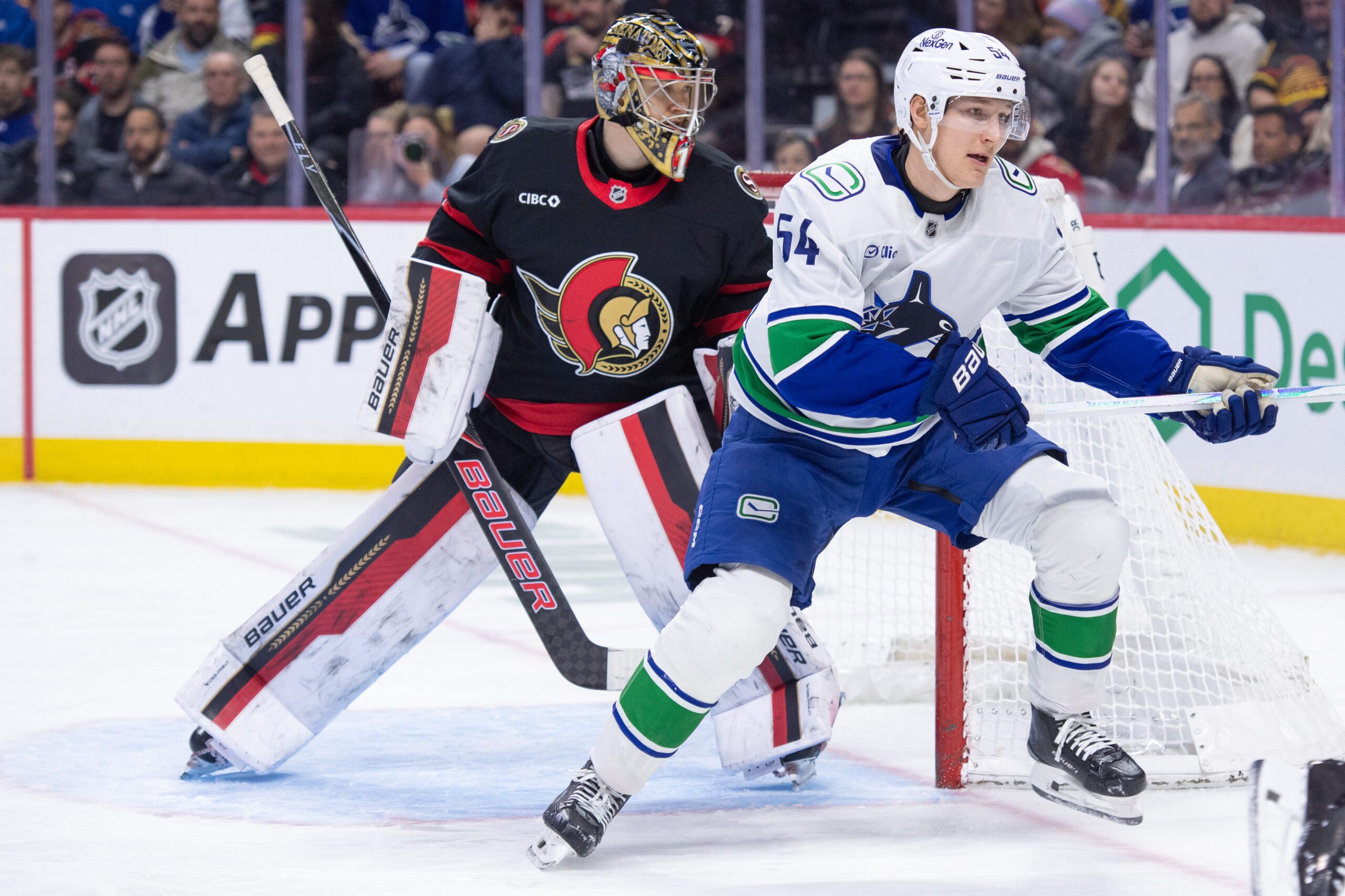 Jan 13, 2026; Ottawa, Ontario, CAN; Ottawa Senators goalie Leevi Merilainen (1) and Vancouver Canucks center Aatu Raty (54) follow the puck in the second period at the Canadian Tire Centre. Mandatory Credit: Marc DesRosiers-IMAGN Images