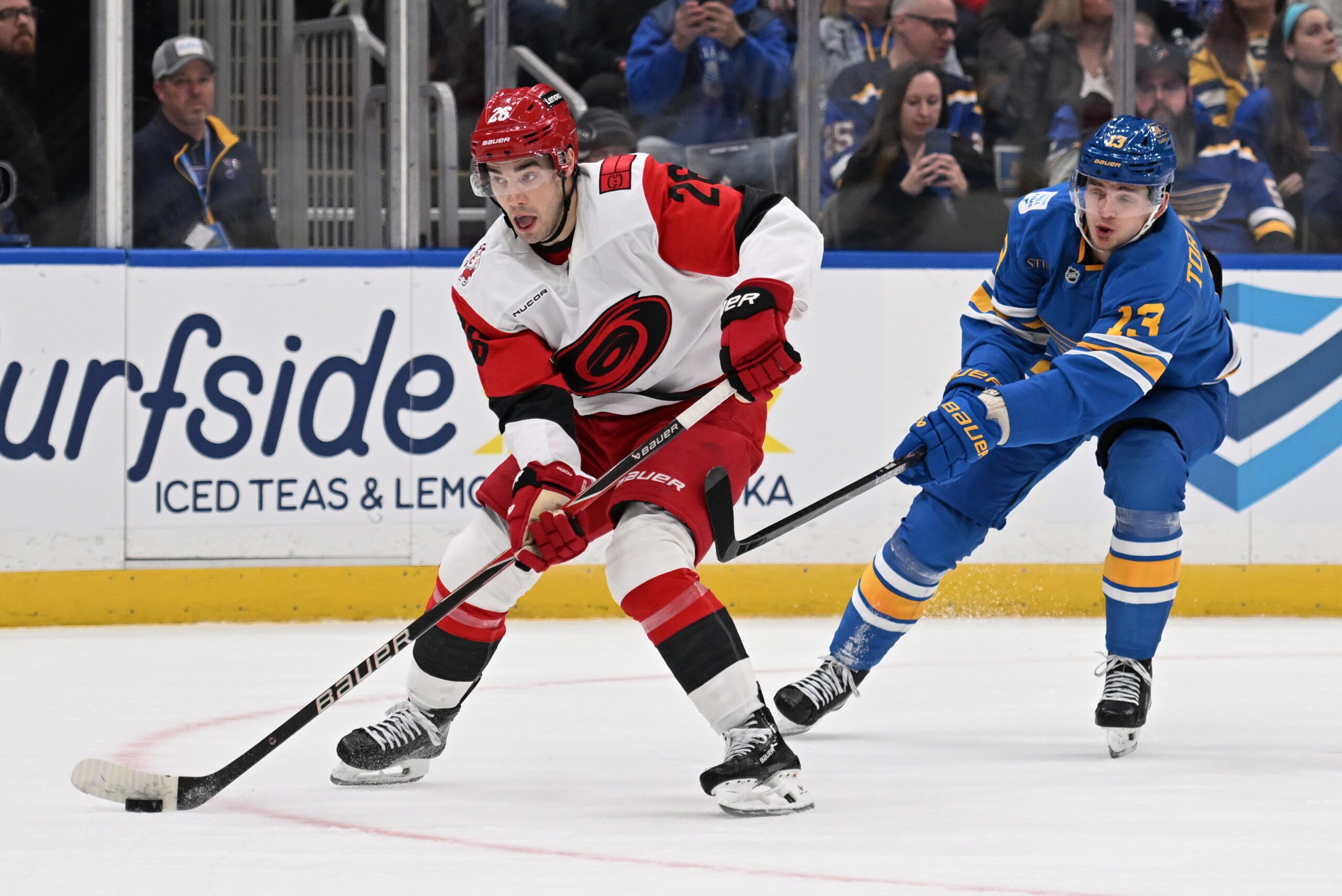 Jan 13, 2026; St. Louis, Missouri, USA; St. Louis Blues right wing Alexey Toropchenko (13) pressures Carolina Hurricanes defenseman Sean Walker (26) in the second period at Enterprise Center. Mandatory Credit: Joe Puetz-Imagn Images