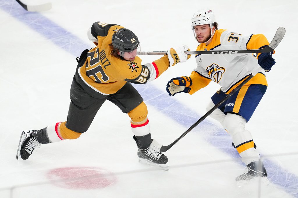 Jan 17, 2026; Las Vegas, Nevada, USA; Vegas Golden Knights right wing Alexander Holtz (26) shoots the puck in front of Nashville Predators defenseman Nick Blankenburg (37) during the third period at T-Mobile Arena. Mandatory Credit: Stephen R. Sylvanie-Imagn Images