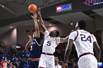 Jan 21, 2026; Spokane, Washington, USA; Pepperdine Waves guard Aaron Clark (3) shoots the ball against Gonzaga Bulldogs forward Emmanuel Innocenti (5) in the second half at McCarthey Athletic Center. Mandatory Credit: James Snook-Imagn Images