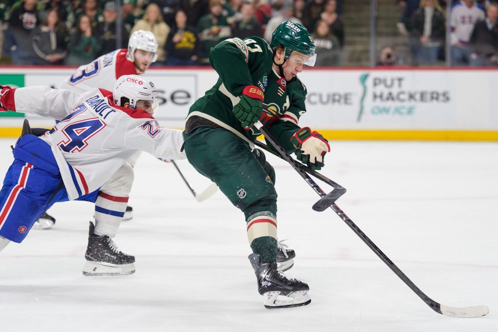 Feb 2, 2026; Saint Paul, Minnesota, USA; Montreal Canadiens center Phillip Danault (24) is penalized for hooking Minnesota Wild left wing Kirill Kaprizov (97) in overtime at Grand Casino Arena. Mandatory Credit: Matt Blewett-Imagn Images