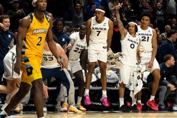 Xavier Musketeers guard Isaiah Walker (7) and Xavier Musketeers guard Roddie Anderson III (0) react to Xavier Musketeers forward Filip Borovicanin (4) hitting a 3-point basket as Marquette Golden Eagles guard Chase Ross (2) reacts in the second half of the game at the Cintas Center in Cincinnati on Saturday, Feb. 14, 2026.