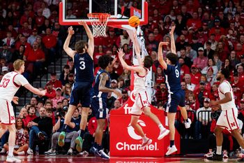 Feb 21, 2026; Lincoln, Nebraska, USA; Nebraska Cornhuskers forward Pryce Sandfort (21) shoots the ball against Penn State Nittany Lions forward Ivan Juric (3), forward Mason Blackwood (1) and guard Melih Tunca (9) during the second half at Pinnacle Bank Arena. Mandatory Credit: Dylan Widger-Imagn Images