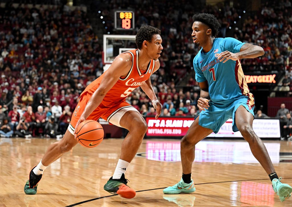 Feb 24, 2026; Tallahassee, Florida, USA; Miami Hurricanes forward Malik Reneau (5) drives to the net past Florida State Seminoles forward Chauncey Wiggins (7) during the first half at Donald L. Tucker Center. Mandatory Credit: Melina Myers-Imagn Images