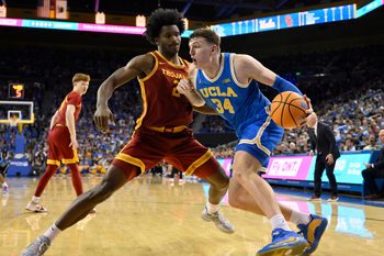 Feb 24, 2026; Los Angeles, California, USA; UCLA Bruins forward Tyler Bilodeau (34) drives to the basket defended by Southern California Trojans forward Ezra Ausar (2) during the second half at Pauley Pavilion presented by Wescom Financial. Mandatory Credit: Robert Hanashiro-Imagn Images