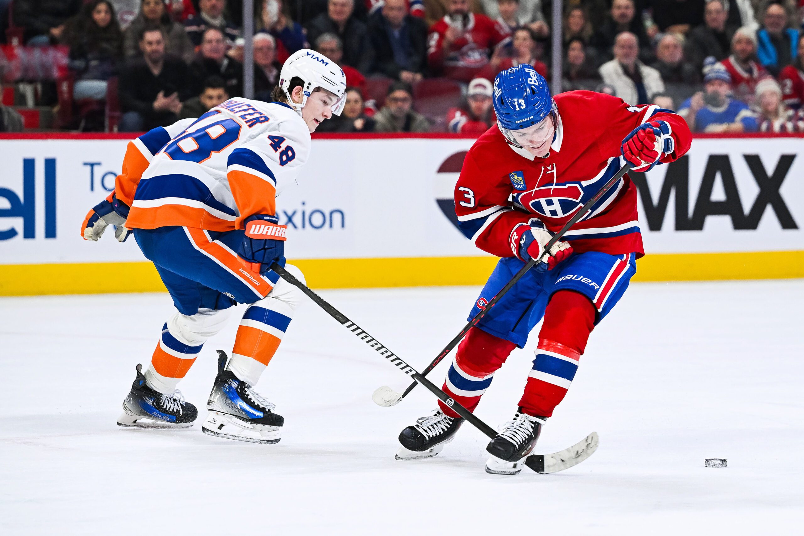 Feb 26, 2026; Montreal, Quebec, CAN; New York Islanders defenseman Matthew Schaefer (48) defends the puck against Montreal Canadiens right wing Cole Caufield (13) during overtime at Bell Centre. Mandatory Credit: David Kirouac-Imagn Images