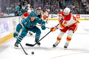 Feb 26, 2026; San Jose, California, USA; San Jose Sharks defenseman Sam Dickinson (6) and Calgary Flames center Nazem Kadri (91) fight for the puck during the first period at SAP Center at San Jose. Mandatory Credit: Bob Kupbens-Imagn Images