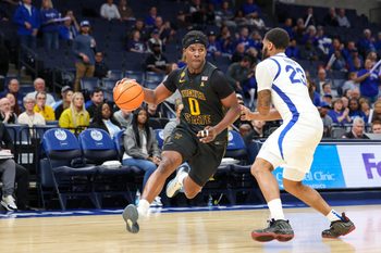 Feb 26, 2026; Memphis, Tennessee, USA; Wichita State Shockers forward Karon Boyd (0) drives to the basket against Memphis Tigers guard Sincere Parker (23) during the second half at FedExForum. Mandatory Credit: Wesley Hale-Imagn Images