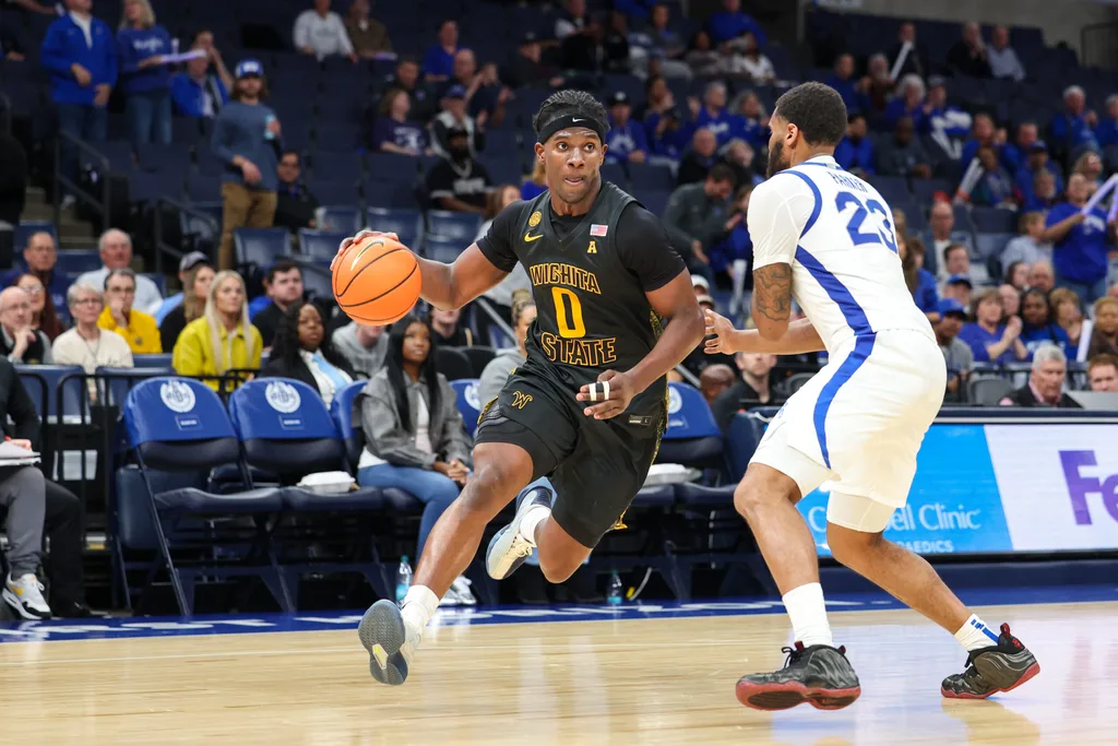 Feb 26, 2026; Memphis, Tennessee, USA; Wichita State Shockers forward Karon Boyd (0) drives to the basket against Memphis Tigers guard Sincere Parker (23) during the second half at FedExForum. Mandatory Credit: Wesley Hale-Imagn Images