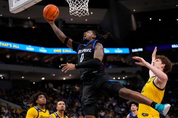 Mar 1, 2026; Milwaukee, Wisconsin, USA;  DePaul Blue Demons guard Brandon Maclin (0) shoots in front of jMarquette Golden Eagles forward Ben Gold (12) during the first half at Fiserv Forum. Mandatory Credit: Jeff Hanisch-Imagn Images