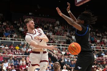 Feb 28, 2026; Stanford, California, USA; Stanford Cardinal forward Aidan Cammann (left) passes against Southern Methodist University Mustangs center Jaden Toombs (right) during the second half at Maples Pavilion. Mandatory Credit: Darren Yamashita-Imagn Images