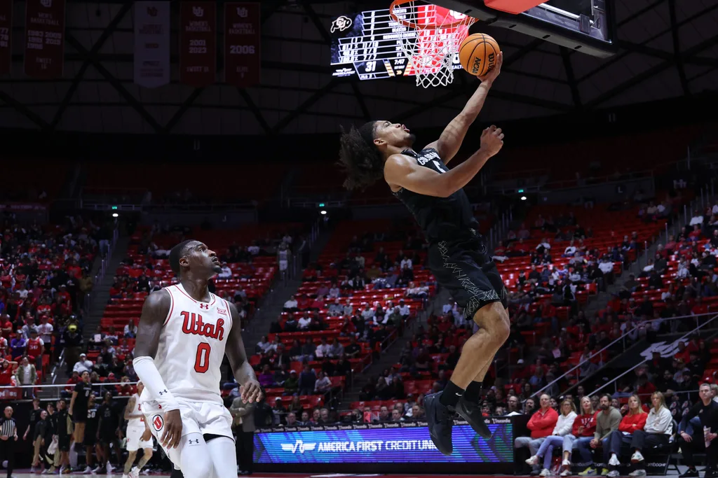 Mar 3, 2026; Salt Lake City, Utah, USA; Colorado Buffaloes guard Josiah Sanders (5) goes for a lay up against Utah Utes forward Seydou Traore (0) during the first half at Jon M. Huntsman Center. Mandatory Credit: Rob Gray-Imagn Images