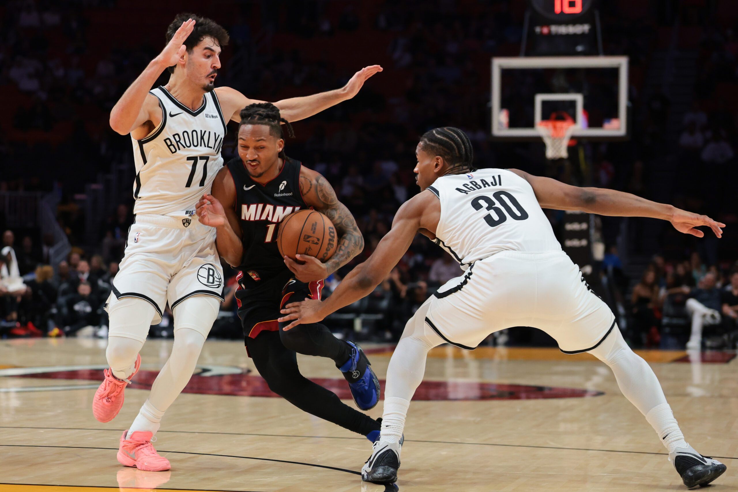 Mar 3, 2026; Miami, Florida, USA; Miami Heat guard Jahmir Young (17) drives to the basket against Brooklyn Nets guard Ben Saraf (77) and guard Ochai Agbaji (30) during the fourth quarter at Kaseya Center. Mandatory Credit: Sam Navarro-Imagn Images