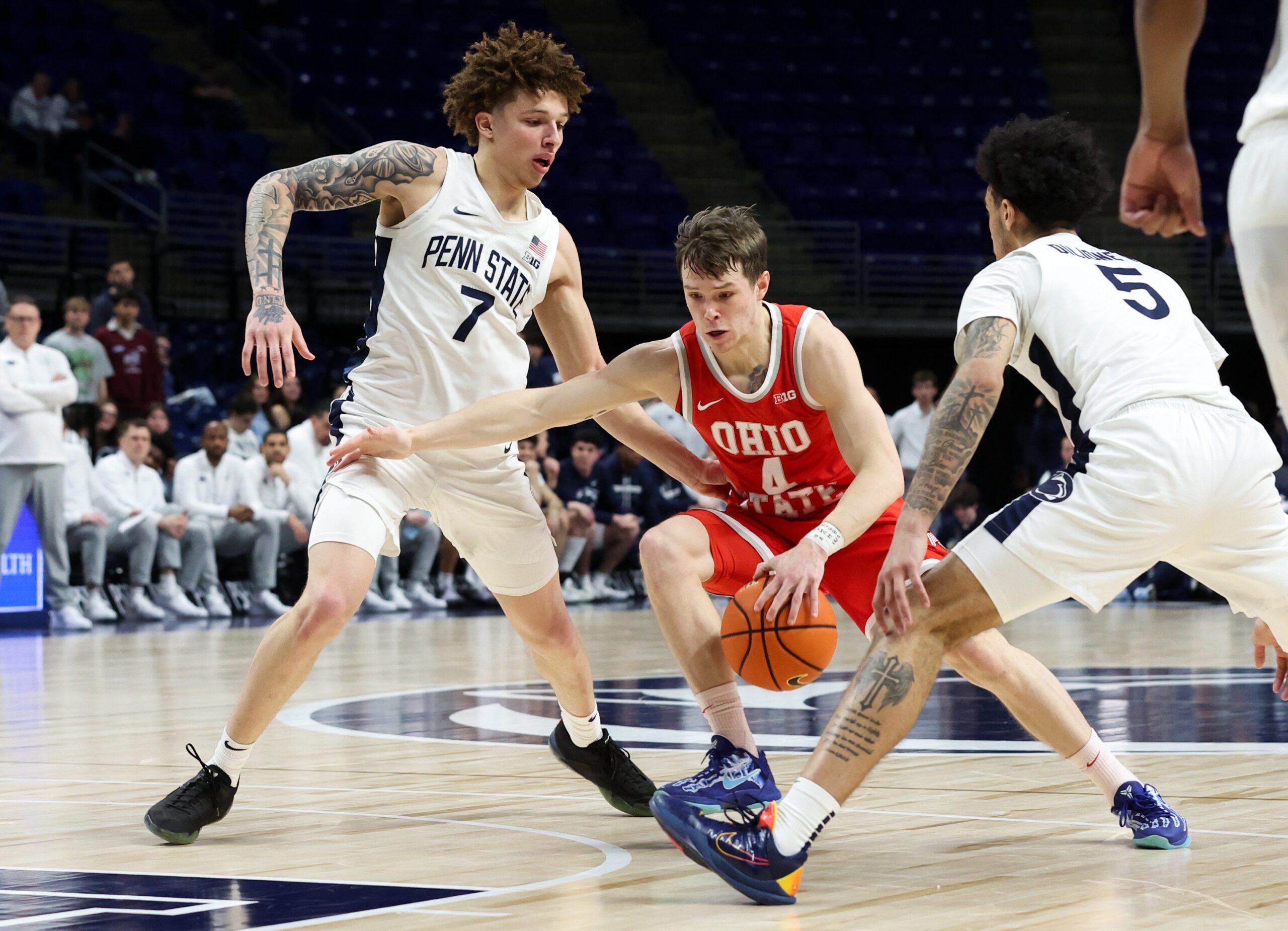 Mar 4, 2026; University Park, Pennsylvania, USA; Ohio State Buckeyes guard Gabe Cupps (4) drives the ball towards the basket as Penn State Nittany Lions guard Freddie Dilione V (5) and guard Dominick Stewart (7) defend during the second half at Bryce Jordan Center. Mandatory Credit: Matthew O'Haren-Imagn Images