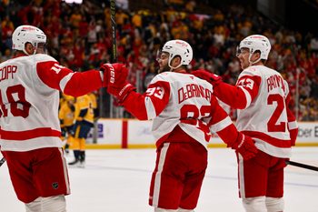 Mar 2, 2026; Nashville, Tennessee, USA;  Detroit Red Wings goaltender Cam Talbot (39) celebrates his goal with center Andrew Copp (18) and left wing Lucas Raymond (23) against the Nashville Predators during the third period at Bridgestone Arena. Mandatory Credit: Steve Roberts-Imagn Images