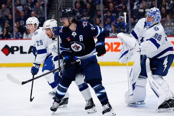 Mar 5, 2026; Winnipeg, Manitoba, CAN;  Winnipeg Jets forward Mark Scheifele (55) jostles for position with Tampa Bay Lightning defenseman Charle-Edouard D'Astous (51) in front of goalie Andrei Vasilevsky (88) during the second period at Canada Life Centre. Mandatory Credit: Terrence Lee-Imagn Images