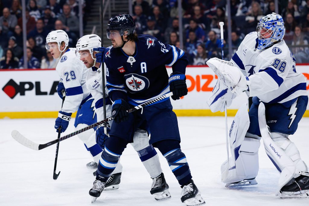Mar 5, 2026; Winnipeg, Manitoba, CAN; Winnipeg Jets forward Mark Scheifele (55) jostles for position with Tampa Bay Lightning defenseman Charle-Edouard D'Astous (51) in front of goalie Andrei Vasilevsky (88) during the second period at Canada Life Centre. Mandatory Credit: Terrence Lee-Imagn Images