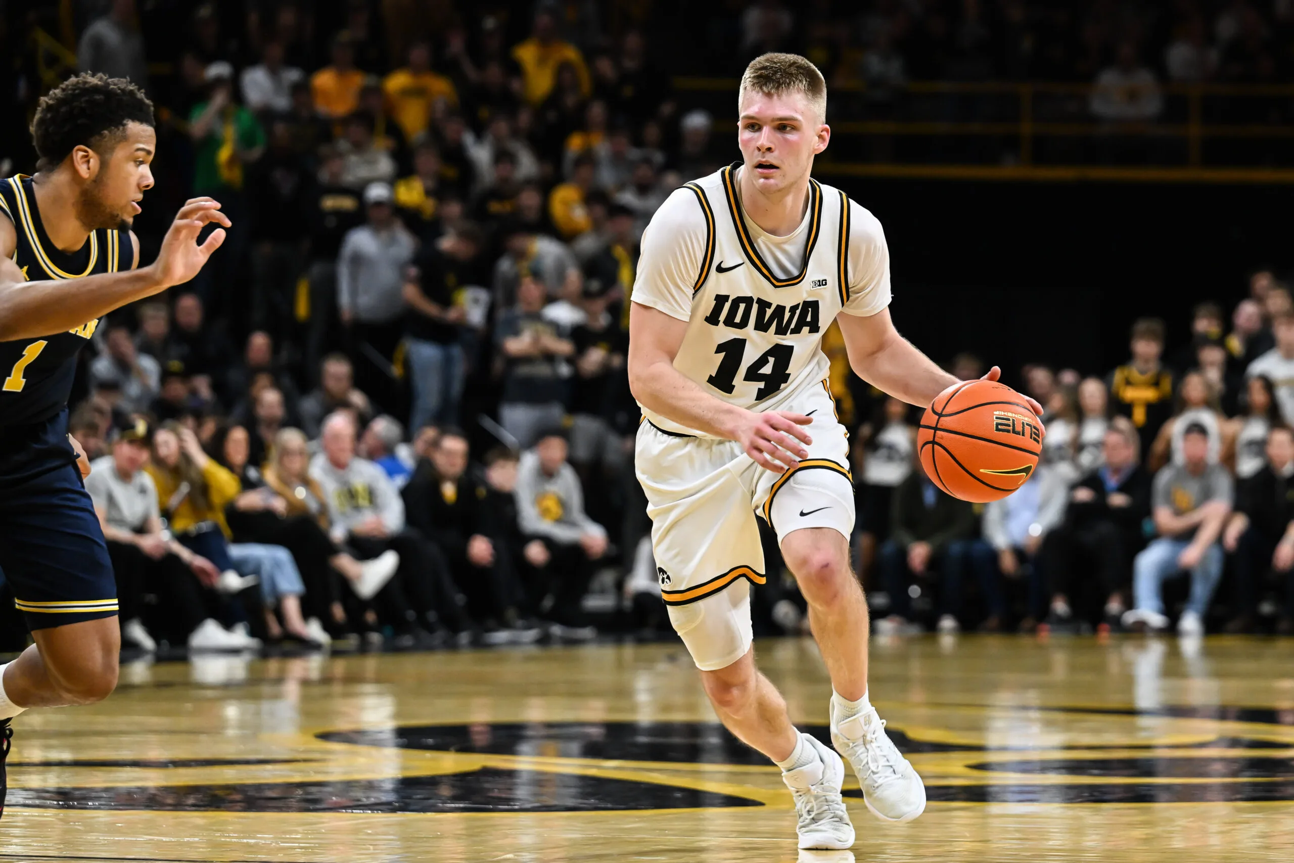 Mar 5, 2026; Iowa City, Iowa, USA; Iowa Hawkeyes guard Bennett Stirtz (14) controls the ball as Michigan Wolverines guard Trey McKenney (1) defends during the second half at Carver-Hawkeye Arena. Mandatory Credit: Jeffrey Becker-Imagn Images