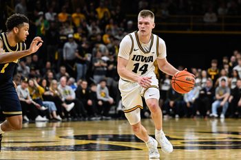 Mar 5, 2026; Iowa City, Iowa, USA; Iowa Hawkeyes guard Bennett Stirtz (14) controls the ball as Michigan Wolverines guard Trey McKenney (1) defends during the second half at Carver-Hawkeye Arena. Mandatory Credit: Jeffrey Becker-Imagn Images
