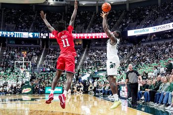 Michigan State forward Coen Carr (55) shoots a 3-pointer against Rutgers forward Chris Nwuli (11) during the second half at Breslin Center in East Lansing on Thursday, March 5, 2026.
