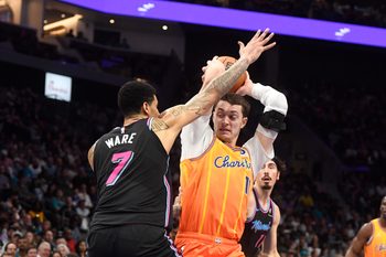 Mar 6, 2026; Charlotte, North Carolina, USA;  Charlotte Hornets center Ryan Kalkbrenner (11) looks to pass as he is defended by Miami Heat center Kel’el Ware (7) during the second half at the Spectrum Center. Mandatory Credit: Sam Sharpe-Imagn Images